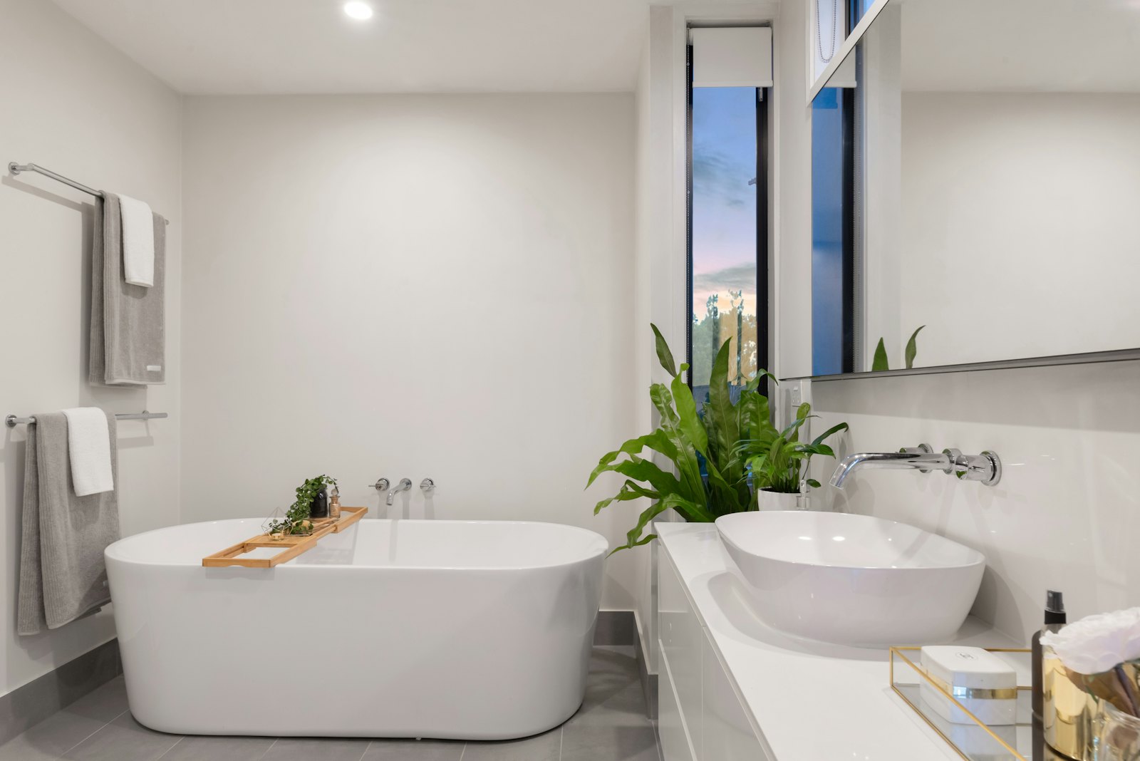 Bright bathroom with a freestanding tub, vessel sink and plants