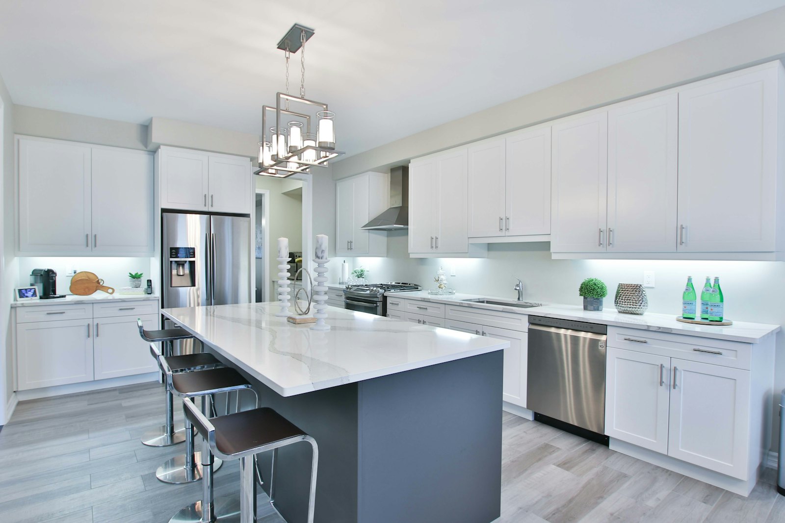 White shaker kitchen with a dark grey island and stainless appliances