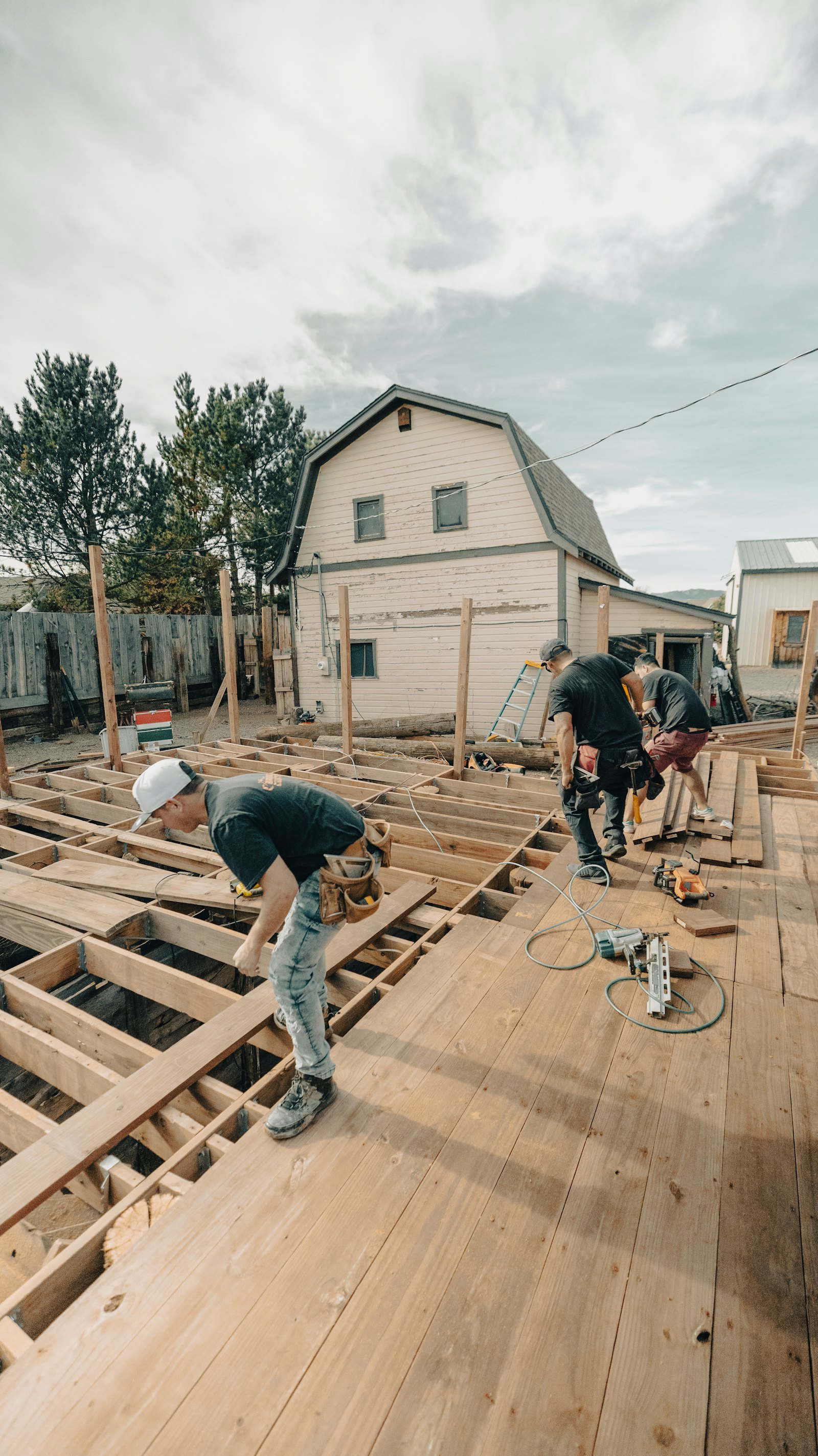 Crew framing a new wooden deck behind a house