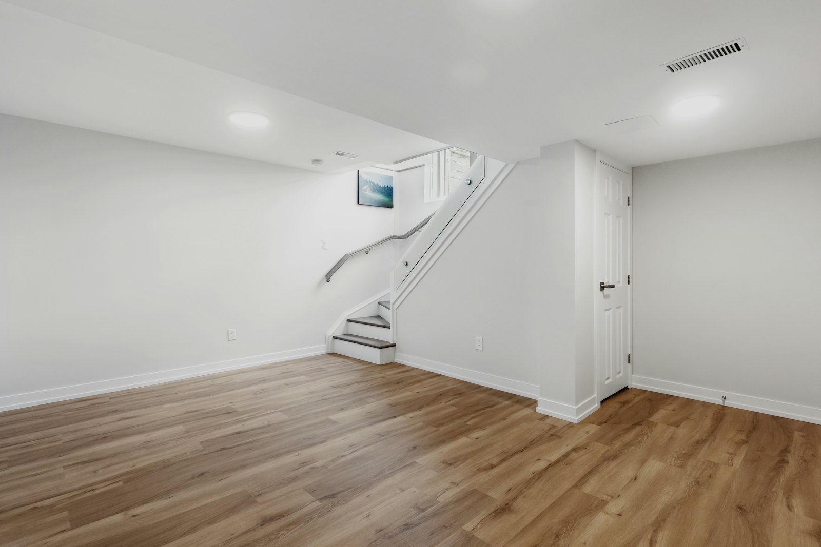 Finished basement room with new stairs and wood-look floor